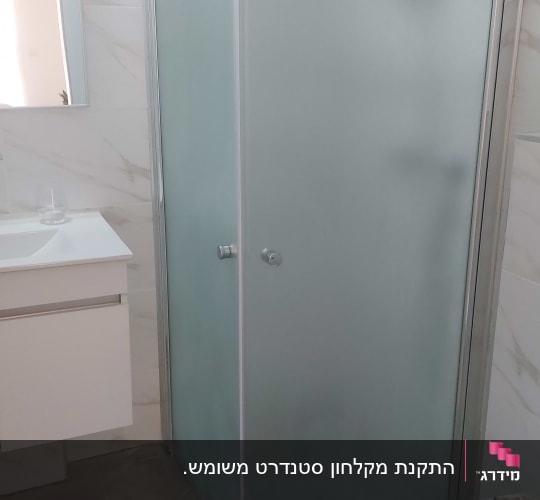 מקלחון פינתי מזכוכית חלבית המותקן בחדר רחצה מעוצב